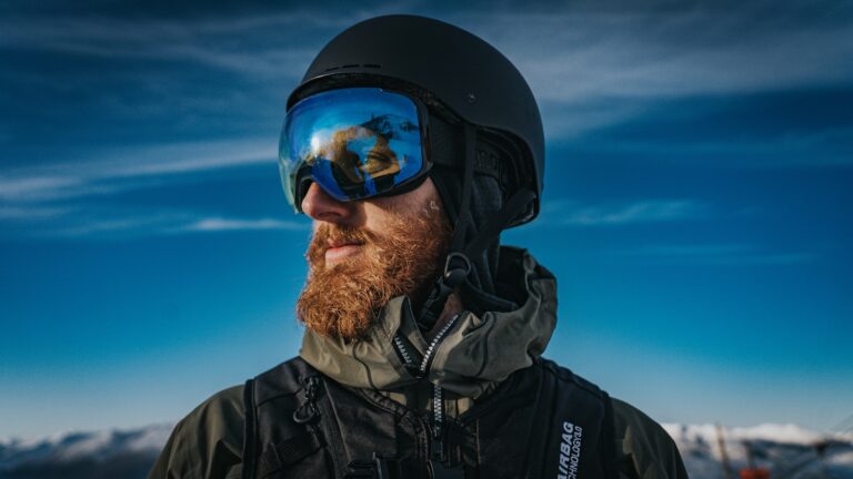 Skier with a helmet and goggles looks away.