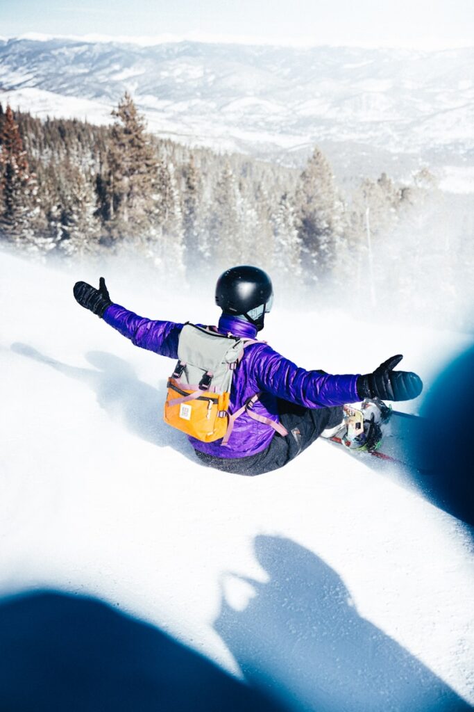 Snowboarder enjoys a downhill run on a sunny day.