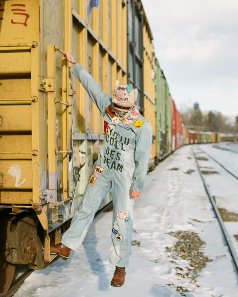 Person in pig mask and overalls on train