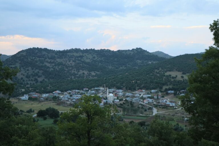 A small village nestled in a valley surrounded by hills.