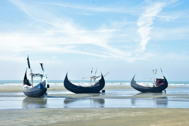 blue and white boat on sea under blue sky during daytime