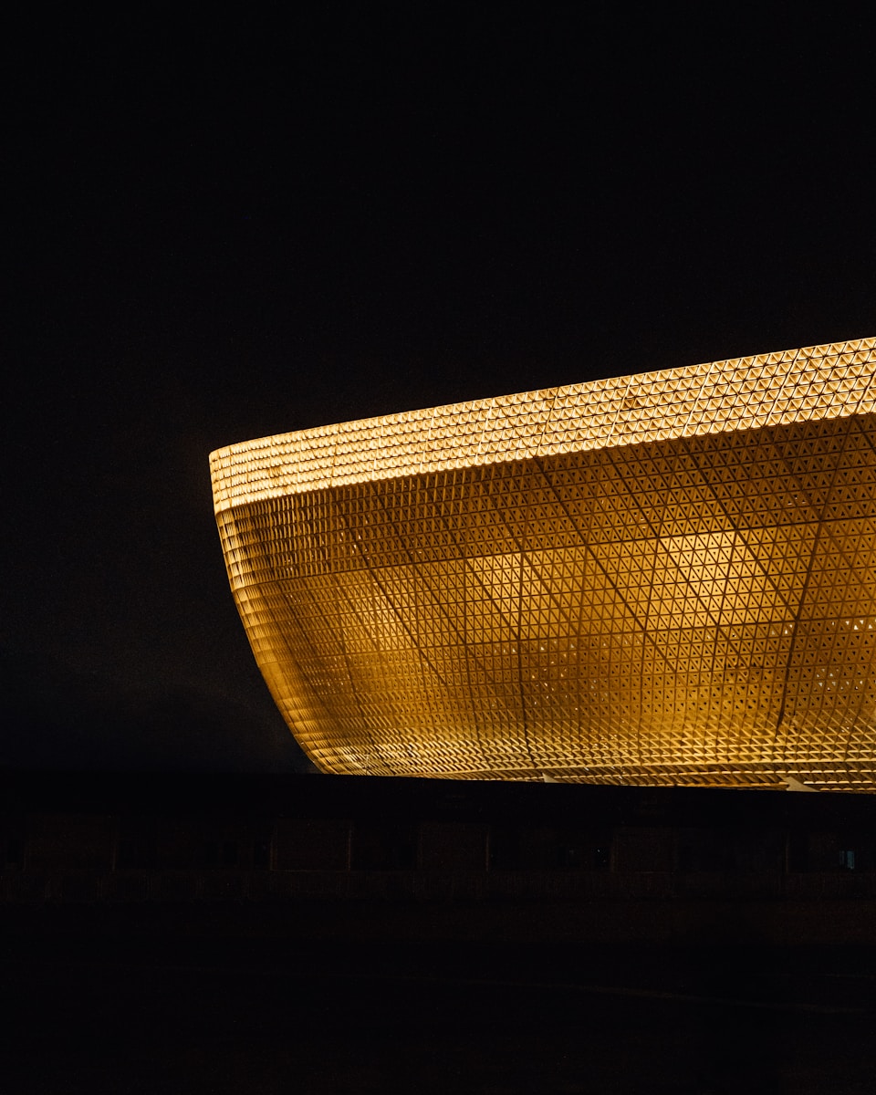 Modern stadium illuminated with golden lights at night