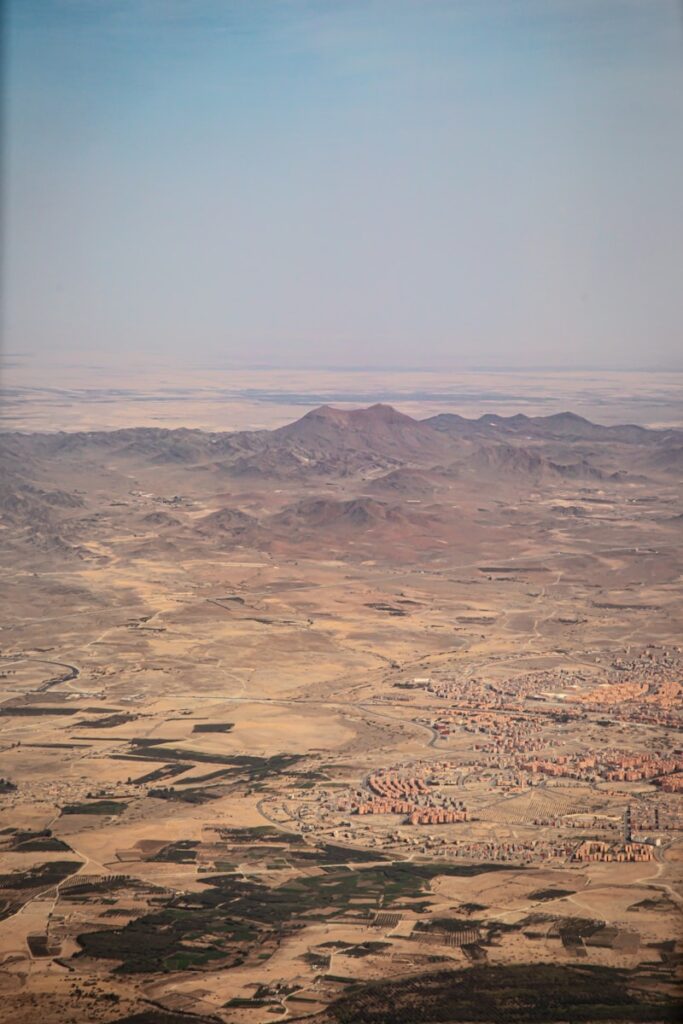 Arid landscape with mountains and scattered buildings.