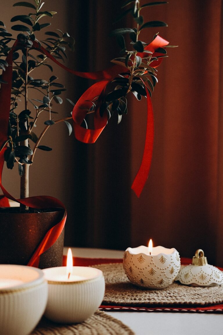 Lit candles and a decorated plant with red ribbon