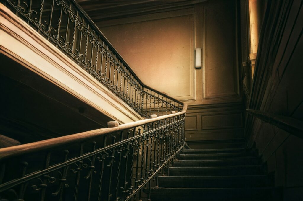 A dark, ornate staircase with a vintage feel