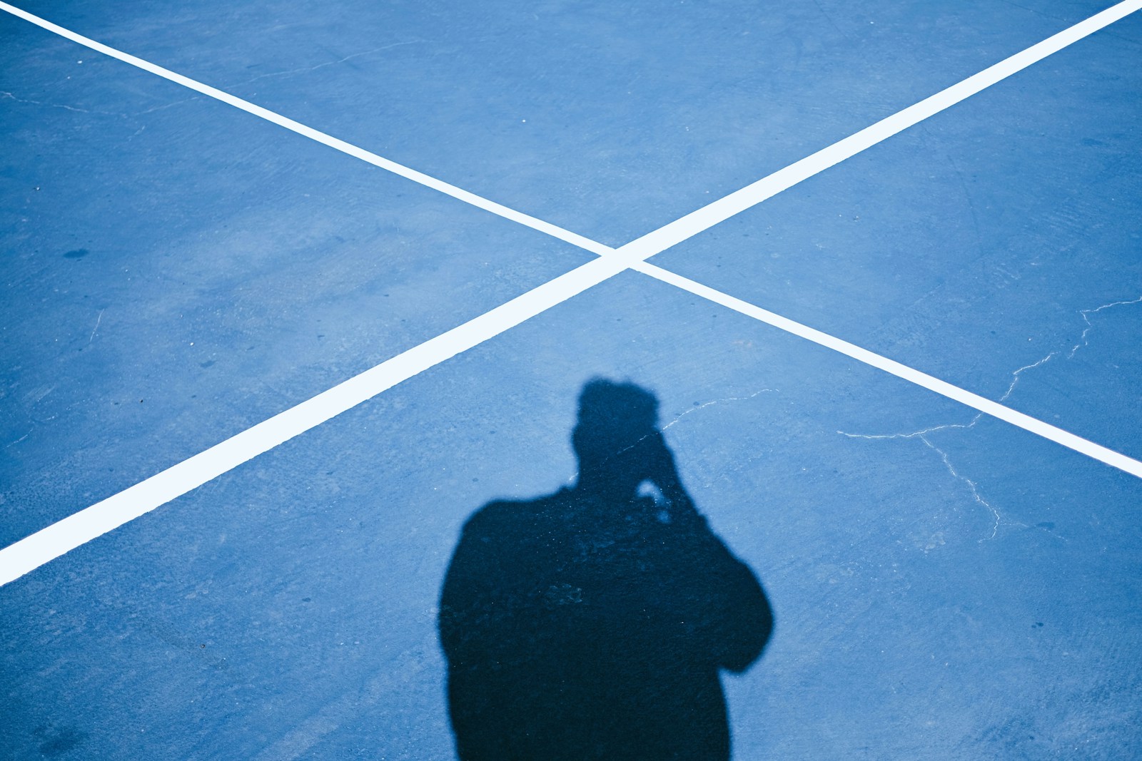Shadow of a person on a blue court